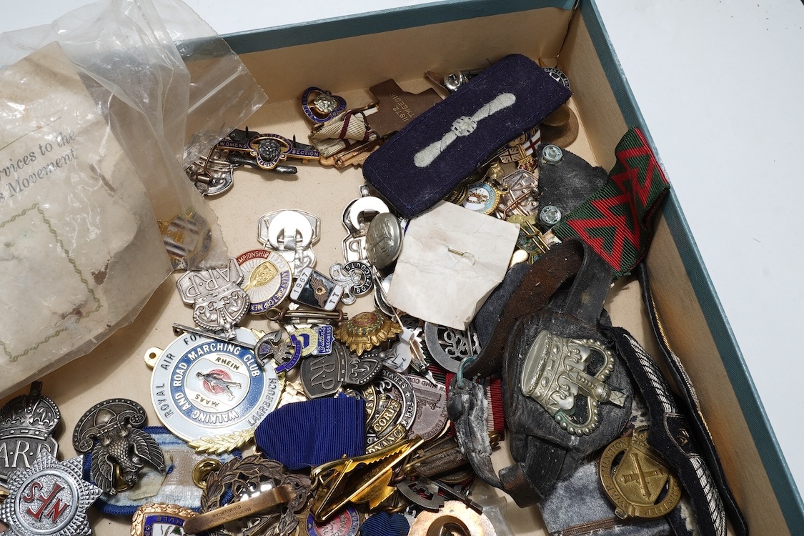 A collection of primarily 20th century military badges, lapel badges, shoulder titles, and other related ephemera, including seventeen military cap badges, cloth badges, ARP badges, etc., together with a military tin box